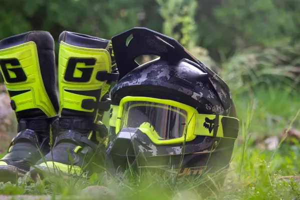 Stock image France, 14, May, 2024: Offroad motorcycle gear including helmet and boots on grass