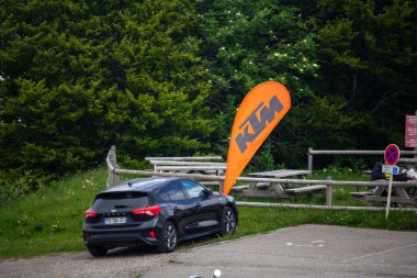 Almanya, 12 Haziran 2024: Kırsal bir bölgede KTM bayrağının yanına park edilmiş siyah araba