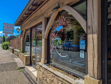 Fransa, 1 Temmuz 2024: Çiçekli ve tabelalı bir köy kafesi cephesi