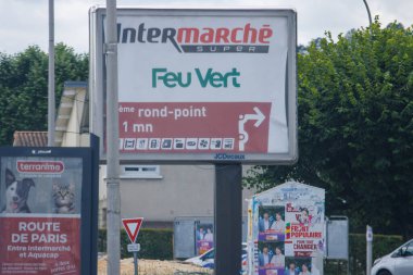 Fransa, 1 Temmuz 2024: Bir kavşakta Intermarche ve Feu Vert tabelası