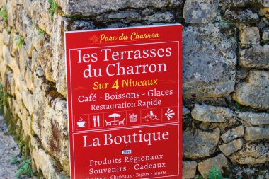 Fransa, 1 Temmuz 2024: Taştan duvarda Les Terrasses du Charron için kırmızı tabela