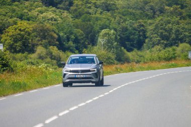 Fransa, 1 Temmuz 2024: Kırsal bir yolda giden bir Peugeot arabasının ön görüntüsü