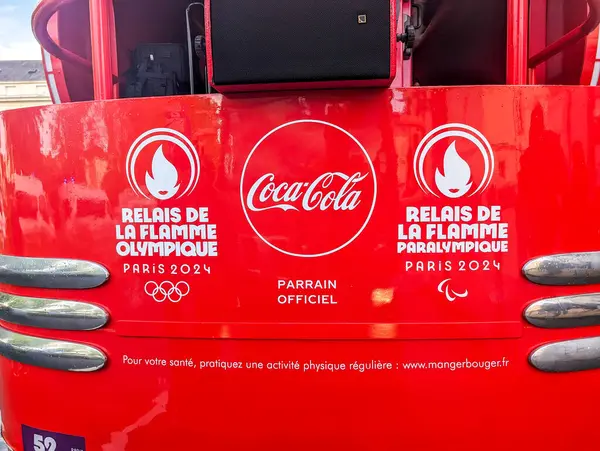 Stock image France, 22 May 2024: Coca-Cola advertisement for Paris 2024 Olympic and Paralympic Torch Relay on red background