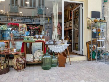 Fransa, 1 Ağustos 2024: Antika mağazası vitrininde çeşitli antika ürünleri sergileniyor