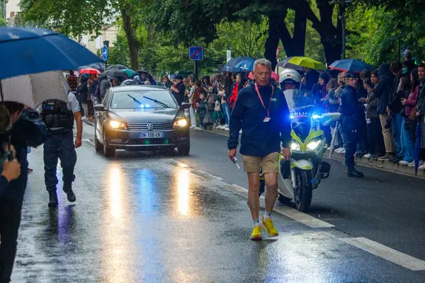 stock image France, 22 May 2024: Security escort during public event in rainy street with crowd