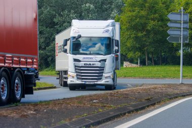 France, 1 July 2024: DAF truck driving on a road with a trailer in a rural area clipart