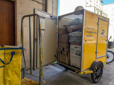 Fransa, 9 Ağustos 2024: La Poste elektrik dağıtım arabası şehir sokaklarında paketlerle dolu
