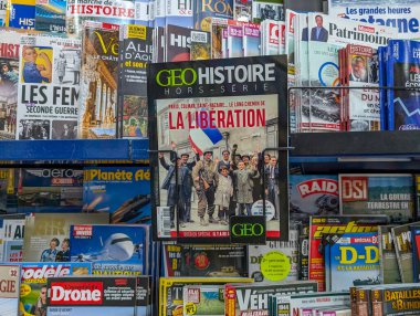 Fransa, 22 Haziran 2024: Tarih ve güncel olaylar hakkında çeşitli yayınların yer aldığı bir mağazada dergi rafı