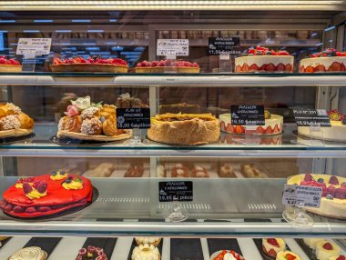 Fransa, 31 Temmuz 2024: Bir pastane vitrininde çeşitli kek ve hamur işleri gösterimi