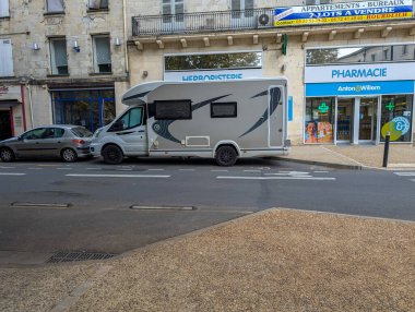 Fransa, 24 Ağustos 2024: Kentsel alandaki eczane yakınlarına park edilmiş bir karavan