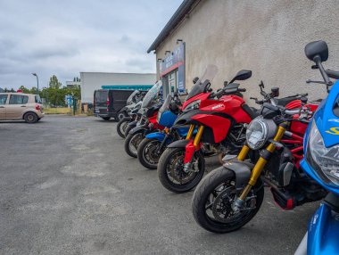 Fransa, 12 Ağustos 2024: Bir binanın önünde park halindeki motosikletler