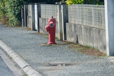 Fransa, 8 Eylül 2024: Sessiz bir yerleşim yerindeki kırmızı yangın musluğu