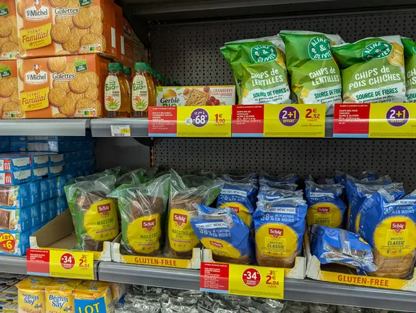 stock image France, 13 August 2024: Grocery store shelf displaying gluten-free chips and biscuits with promotional offers