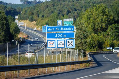 Fransa, 10 Ağustos 2024: Manoire karayolu üzerinde manzaralı orman manzaralı dinlenme alanı gösteren yol tabelası