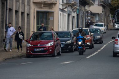 Fransa, 08 Eylül 2024: Motosikletçi Park Edilmiş Arabalarla Yoğun Şehir Caddesinde Yola Çıktı