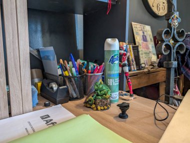 Fransa, 13 Ağustos 2024: Kalemler, deodorantlar, biblolar, saatler ve evrak işleri ile çalışma masası