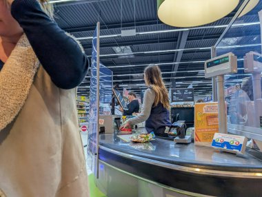 Fransa, 11 Eylül 2024: Süpermarket kasiyer işlemleri ve yakınlarda bekleyen müşterilerle kontrol ediliyor
