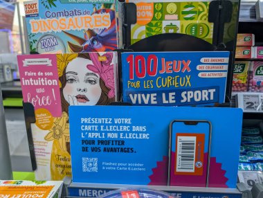 Fransa, 12 Ağustos 2024: Çok sayıda renkli kitap ve mağazada bir reklam sergisi.