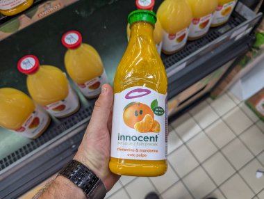 Fransa, 10 Ağustos 2024: Süpermarkette bir şişe Innocent Clementine ve Mandarin suyu tutuyor