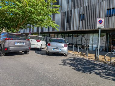 France, 16 August 2024 : Cars Parked in Front of Modern Building with No Parking Sign clipart