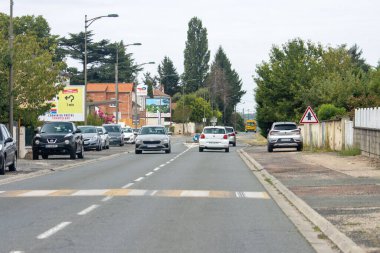 Fransa, 15 Ağustos 2024: Otomobillerle kavşakta yerleşim alanı trafik ışıkları lambaları direkleri