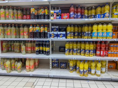 Fransa, 10 Ağustos 2024: Süpermarket raflarında çeşitli meşrubat şişeleri sergilendi