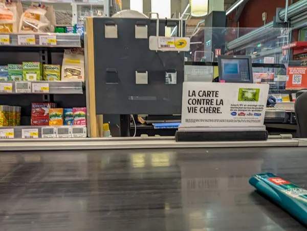 Fransa, 13 Ağustos 2024: Süpermarkette, sadakat kartını destekleyen reklamlarla kasiyer