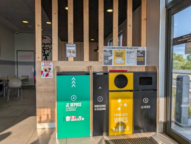 Fransa, 18 Ağustos 2024: KFC 'nin bir restoranında geri dönüşüm ve atık kutuları.