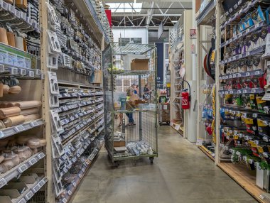 Fransa, 13 Temmuz 2024: Araç gereç, malzeme ve rafları düzenleyen işçilerle donanım mağazası koridoru