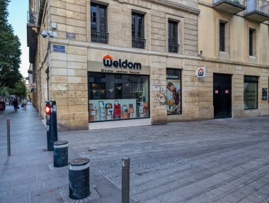 Fransa, Bordeaux, 05 Ekim 2024: Akşam gökyüzü altında dükkan ve yayaların olduğu sokak köşesi.