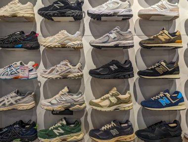 France, 8 May 2024: Display of various New Balance sneakers on a retail wall clipart