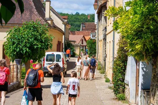 Fransa, 1 Temmuz 2024: Yaz boyunca tarihi bir köyde dar bir sokakta yürüyen turistler