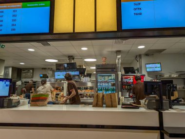 Fransa, 27 Eylül 2024: Fast food restoranı çalışanları bekleyen müşteriler için sipariş hazırlıyor