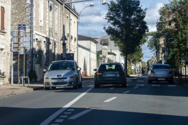 Fransa, 08 Eylül 2024: Binalarla çevrili park edilmiş ve hareket halindeki araçlarla sokak sahnesi.
