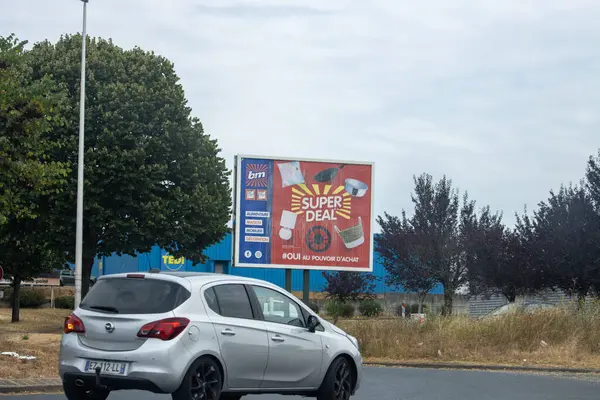 Fransa, 15 Ağustos 2024: Şehir Bölgesi 'nde Arabaların Süper Anlaşma Billboard' undan Geçişi