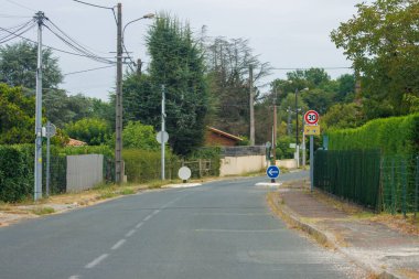 Fransa, 15 Ağustos 2024: Trafik işaretleri ve yeşillikleri olan sakin bir banliyö caddesi