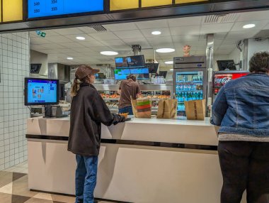 Fransa, 27 Eylül 2024: Müşteriler bir fast-food restoranında yemek sipariş ediyorlar