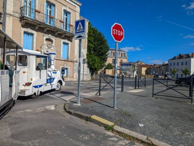 Fransa, 16 Ağustos 2024: Küçük bir kasabada dur işareti, yaya geçidi ve turist treni ile sokak manzarası