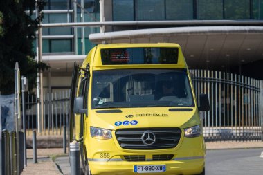 Fransa, 16 Ağustos 2024: Sarı minibüs şehir ortamında açık kapılı
