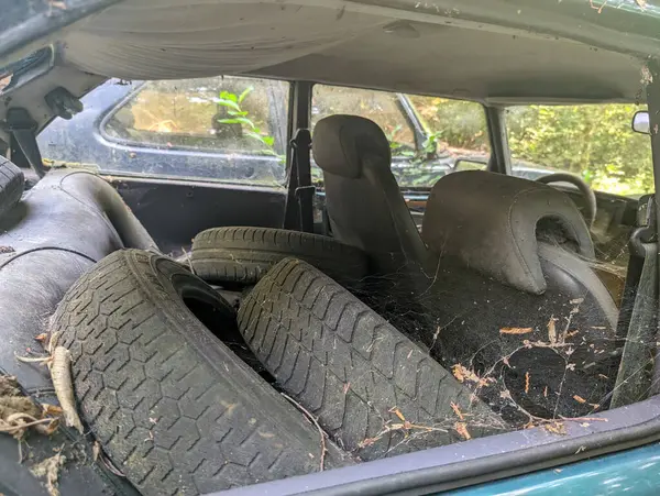 Fransa, 28 Temmuz 2024: Eski lastikler ve enkazlarla dolu terk edilmiş bir arabanın içi