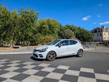 Fransa, 16 Ağustos 2024: Beyaz Renault Clio şehir meydanında kareli kaldırıma park etti