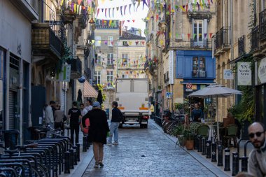 Fransa, Bordeaux, 05 Ekim 2024: Renkli bayraklar hareketli Avrupa caddesini hareketli atmosferle süslüyor.
