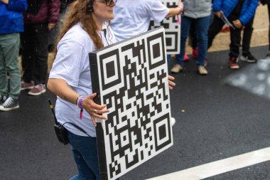 Fransa, 22 Mayıs 2024: Halka açık etkinlik sırasında elinde büyük bir QR kod işareti bulunan kişi