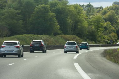 Fransa, 08 Eylül 2024: Yeşillik ağaçlarla çevrili bir otoyolda giden arabalar