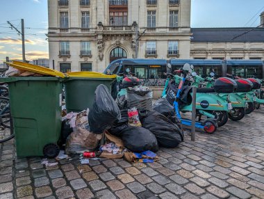 Fransa, Bordeaux, 06 Ekim 2024: Tarihi yapı sahnesi yakınlarında taşan çöp bidonları ve elektrikli scooterlar