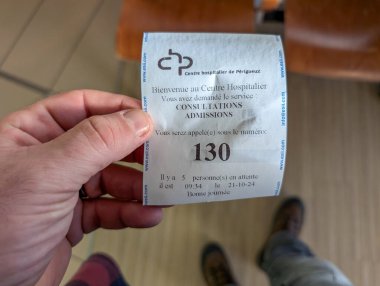 Fransa, 21 Ekim 2024: Hastanenin 130 numaralı bileti elinde..
