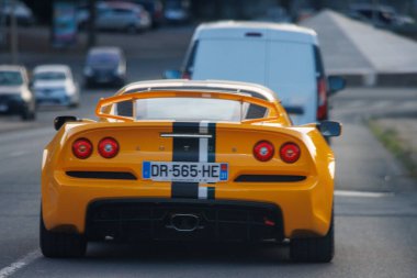 Fransa, 10 Ağustos 2024: Sarı bir spor arabanın şehir caddesinde sürüşü