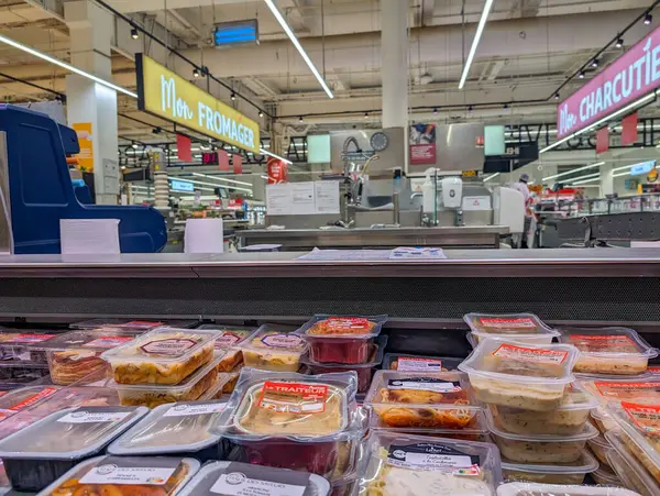 Fransa, 22 Mayıs 2024: Süpermarket bölümü tabela altında peynir ve yiyecek sergiliyor