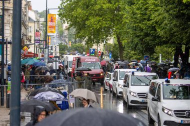 Fransa, 22 Mayıs 2024: Yağmurlu bir günde kalabalık şehir caddesi ve şemsiyeler ve araçlar
