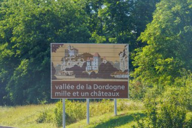 France, 01 July 2024 : Vallee de la Dordogne road sign amidst lush green trees clipart